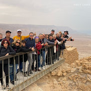 Group of tourists taking a joyful photo at Masada in the Judean Desert.