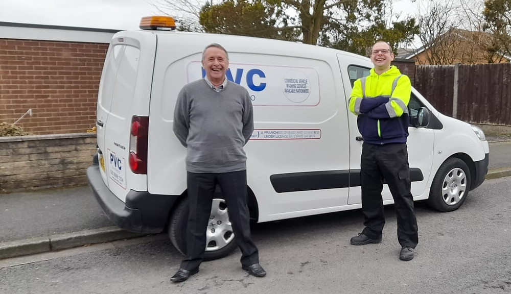 Father and son standing by a van