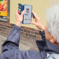 Older adul using mobile phone to take images of their neigbourhood