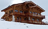 Le chalet La Gélinotte et sa façade en mélèze sous la neige, location de chalet haut de gamme entre Megève et Combloux