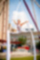 Aerial Performer doing splits between her aerial silks with arms out on either side.