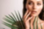 White woman with healthy skin of body and palm leaves. Tanned body of an attractive girl w