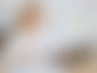 Žena sedí pri stole s laptopom, držiac dokument "Marketing Review". Na tabuli poznámky, graf. Pozitívna atmosféra kancelárie.