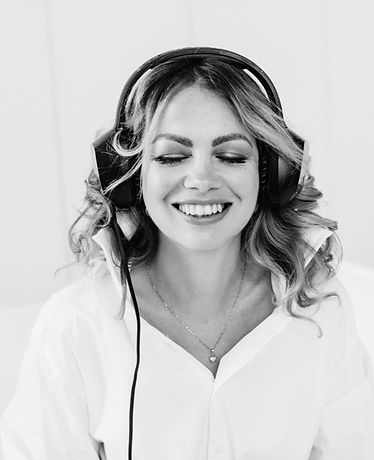 žena počúva podcast a smeje sa, uvolnená atmosféra, zavreté oči