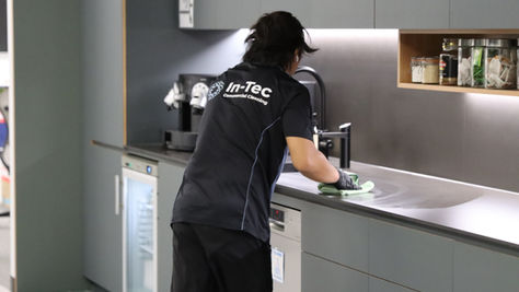 In-Tec cleaner wiping kitchen bench