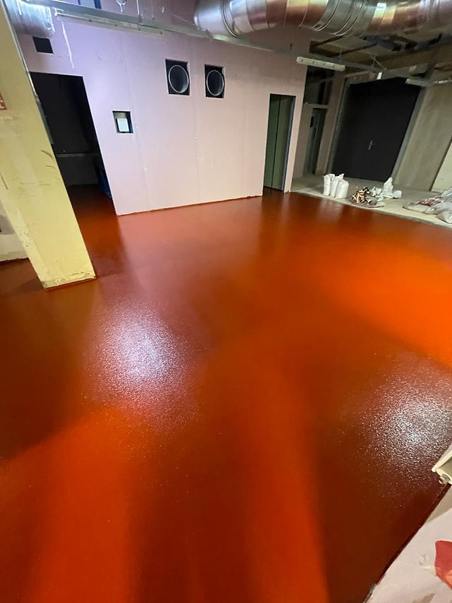 Red resin flooring of in big empty room