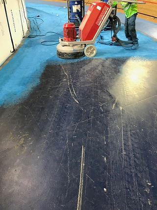 A man grinds a floor with a heavy machine
