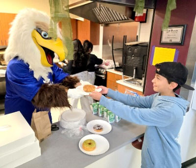 Colorado Credit Union mascot, Cash the eagle, serving breakfast to kid