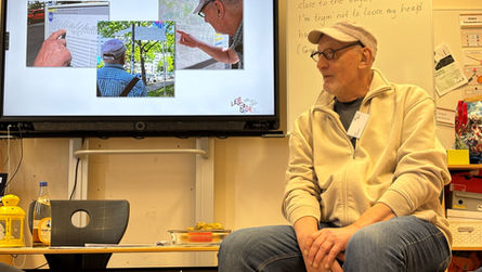 Älterer Herr sitzt auf einem Stuhl