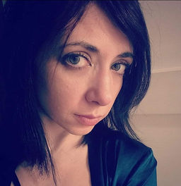Creative professional headshot of Emily Carmen in a emerald green top