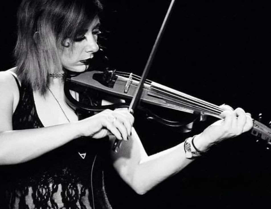 Background Wallpaper For Webiste Shows Emily Carmen Dressed In A Lace Black Top Playing her Electric Yamaha Silent Violin She iS Wearing Fairy GOthic Makeup And HAs Shoulder Length Blonde Hair  It iS in Black And White