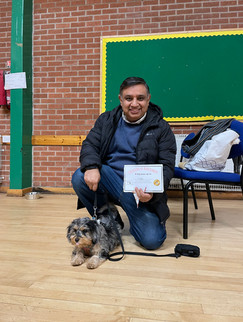 an owner poses with their dog after graduating from class