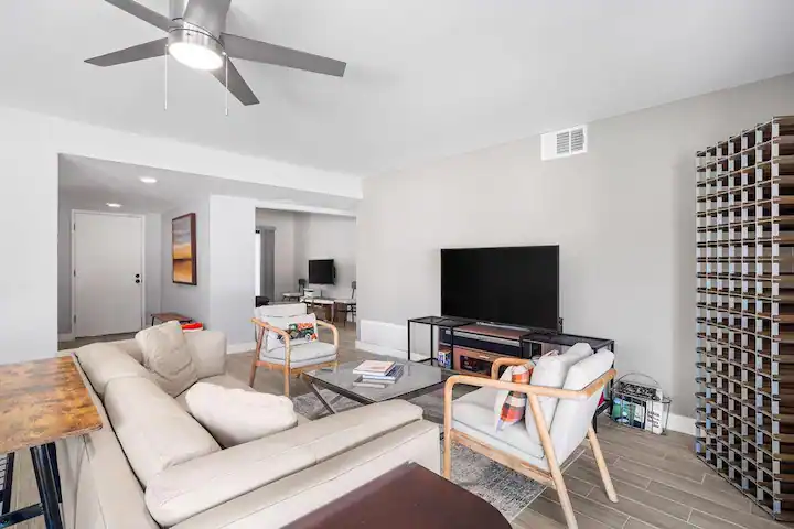 living room in cathedral city vacation rental with flat screen tv, ceiling fan, and large cream couch