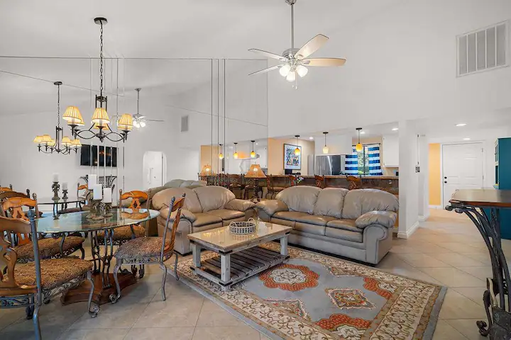 a large open concept living space with dining table, leather couches, and large kitchen island