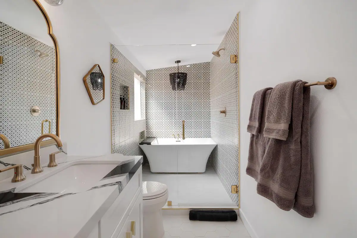 master bathroom in palm desert vacation rental with shower and tub room and modern vanity with black and white marble countertop