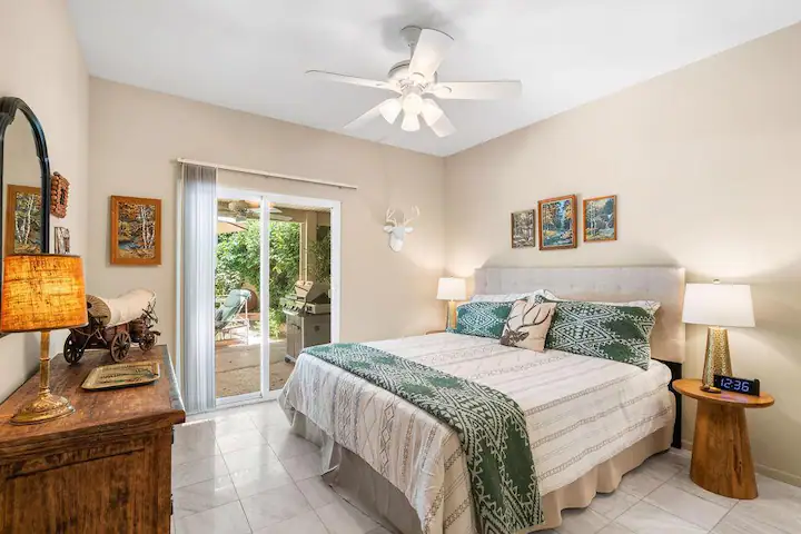 primary bedroom in Rancho Mirage vacation home with large bed, tile flooring, and ceiling fan