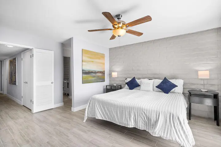 master bedroom in cathedral city vacation rental with large bed, ceiling fan, and lots of natural light