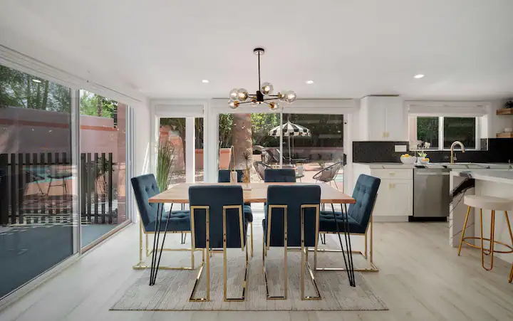 open concept dining room in palm desert vacation rental with modern dining table and large sliding glass doors to backyard with private pool