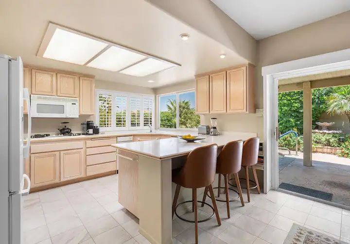 open-concept kitchen in Rancho Mirage vacation rental home with large peninsula and sliding door to the backyard