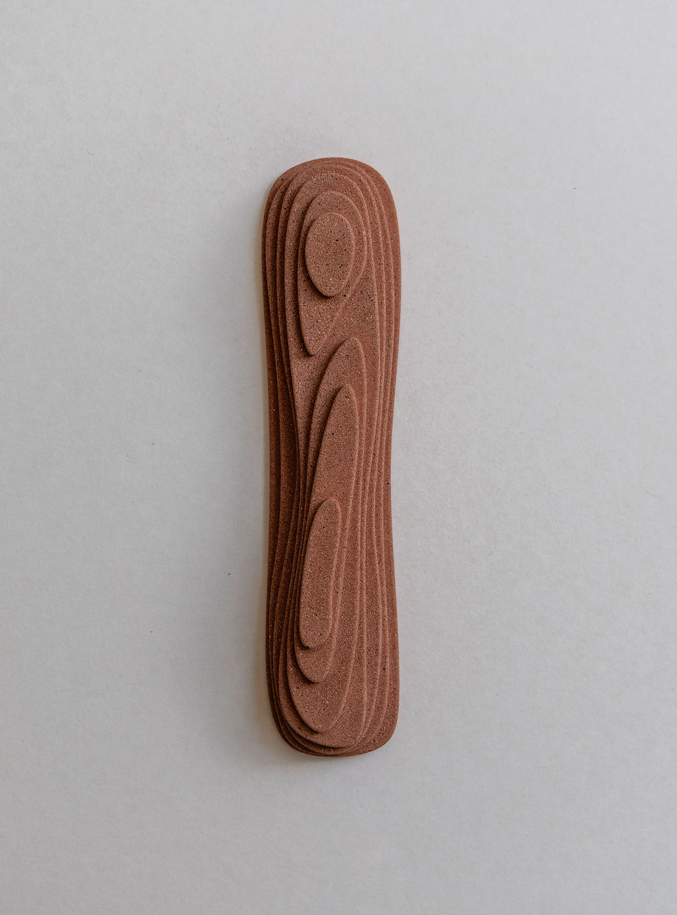 Thumbnail: A single earthy-brown sandstone mezuzah case standing vertically, showcasing a modern design with subtle organic topography.