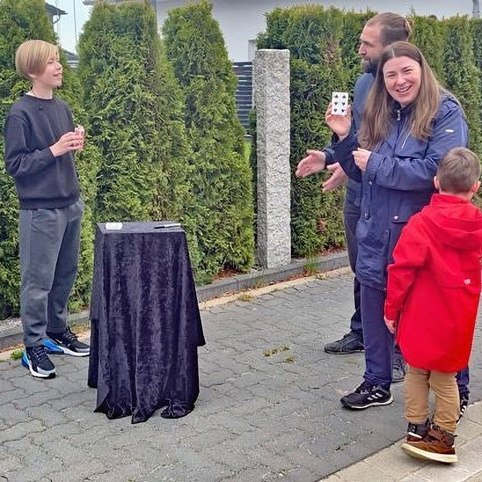 Jamie führt den Zaubertrick Teleportation mehreren Zuschauern vor