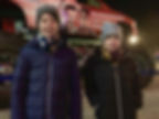 Jamie und Julien in Winterjacken stehen vor einen Monstertruck von den Ehrlich Brothers
