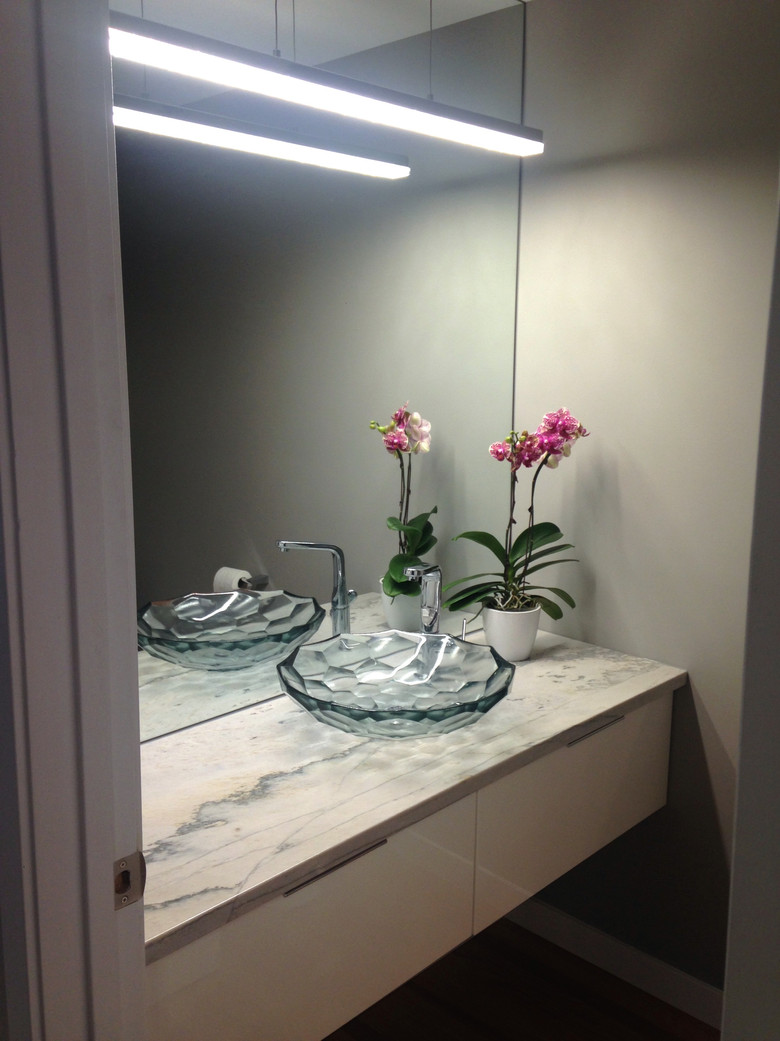 Contemporary powder room. Granite countertop. Faceted glass sink. Linear light fixture.