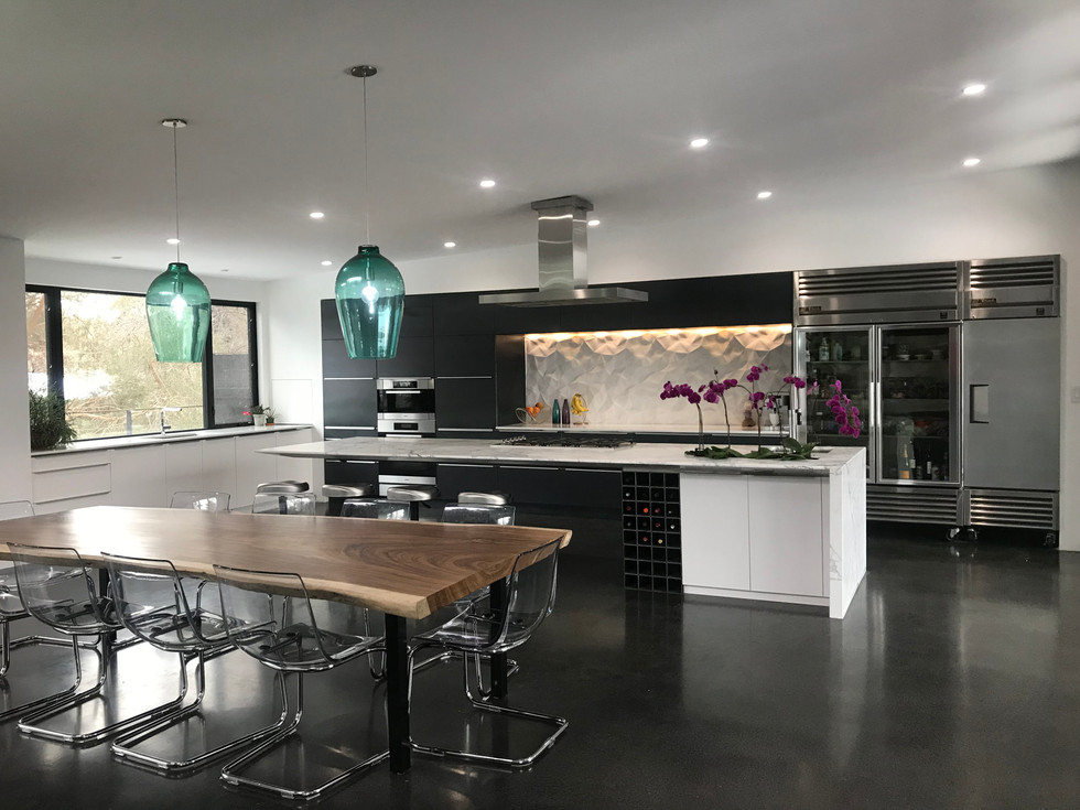Modern kitchen. White flat cabinets. Raw steel cabinets. 3D tile. Poured charcoal concrete floor. 14' floating island. Statuario marble island countertop.
