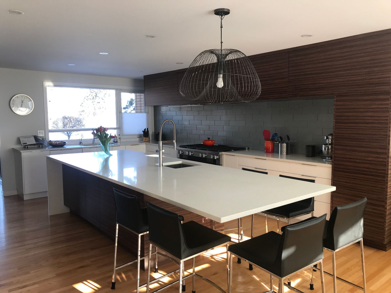 Modern Kitchen. Flat white cabinets. Horizontal tiger wood cabinets. Large island. Quartz countertop. Waterfall edge. Floating overhang. Glass tile backsplash. 1/3 2/3 large subway pattern.