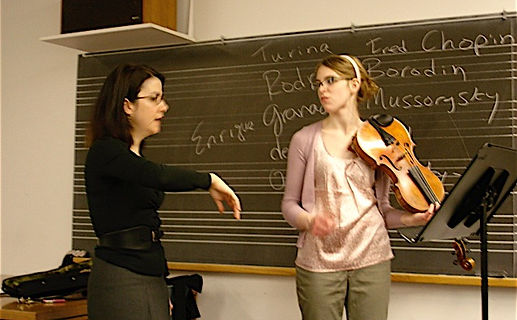 Sarah Plum teaching a student with chalkboard in the background