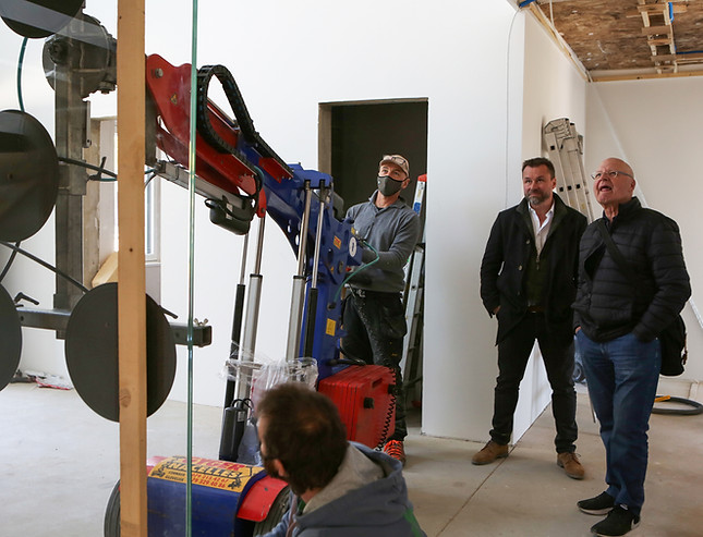 Masini Studio Solutions Architecturales et ses partenaires réalisant la pose du garde corps en verre d'un escalier