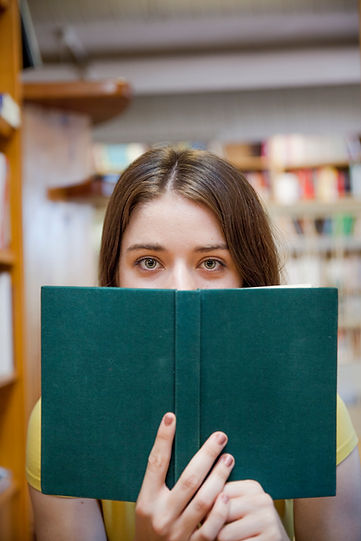 teen-girl-covering-face-with-book-library.jpg