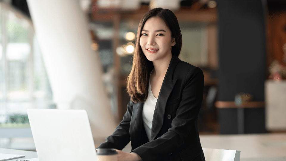 An employee sitting at her office desk, focused on her laptop work.