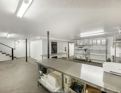 Spacious commercial prep kitchen and storage area with stainless steel work surfaces, open floor plan, storage shelving, and dedicated back-of-house support space at 851 Highway 441 South in Clayton, Georgia.