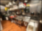 Fully stocked commercial restaurant kitchen with smallwares and kitchen equipment.