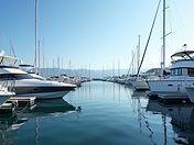 A serene, wide-angle landscape shot of a modern marina in North Vancouver, BC, with yachts