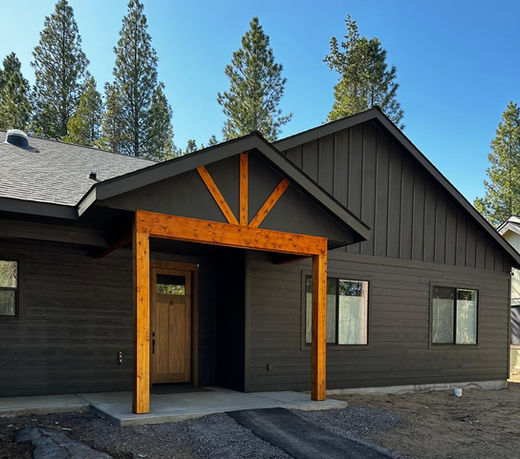 The front of a matte black exterior with raw wood trim.