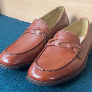 Pair of cognac leather loafers with braided strap detail