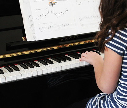 Young girl playing beginner piano