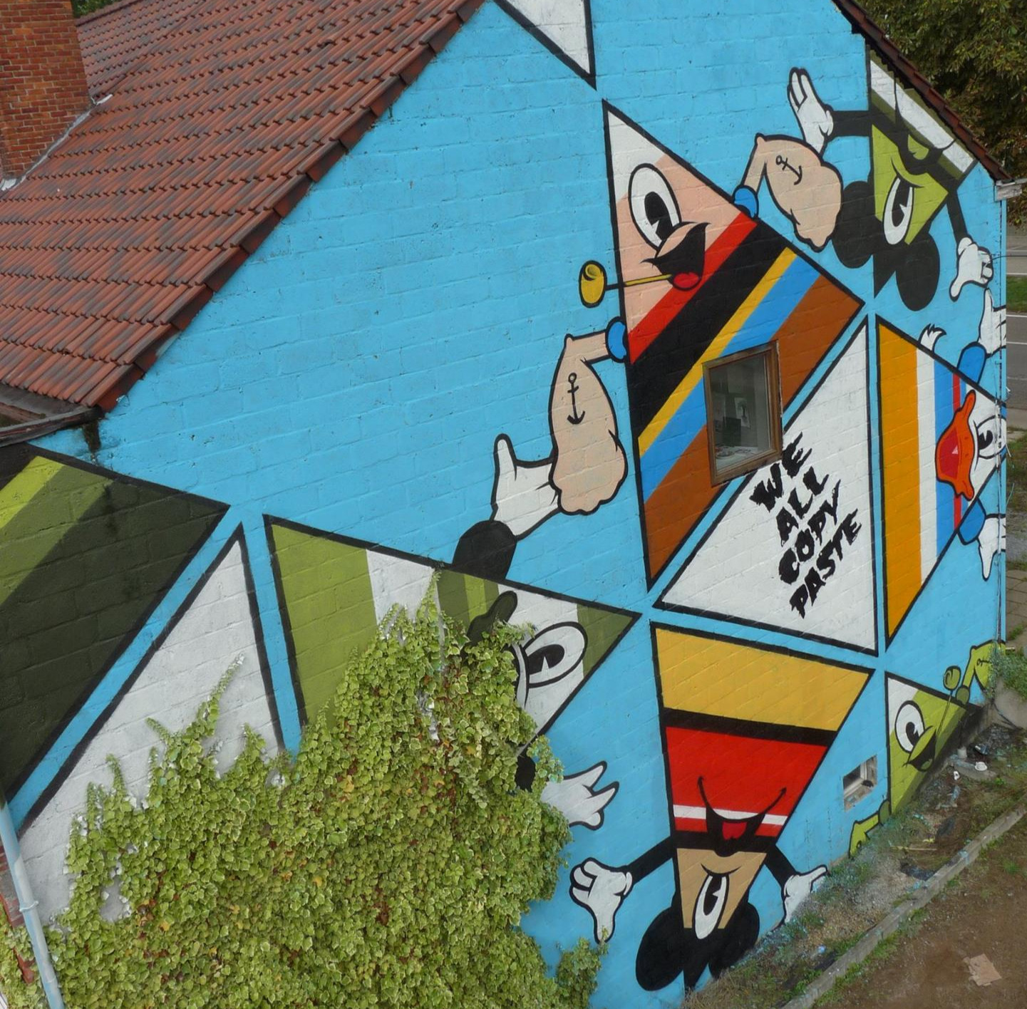 Street art mural op gevel Genk – We All Copy Paste graffiti kunstenaar