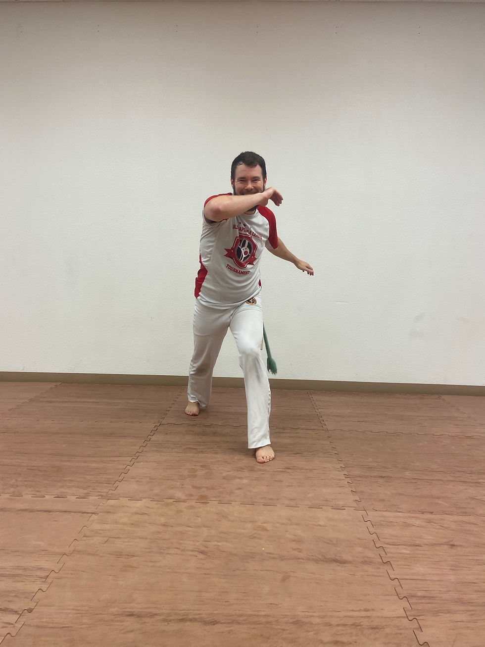 Capoeira student landing Queixada kick back in Ginga position