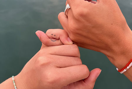 verschränkte kleine Finger bilden ein Smiley Tattoo