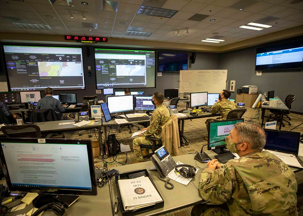 Military officers looking at large screens and computers of information