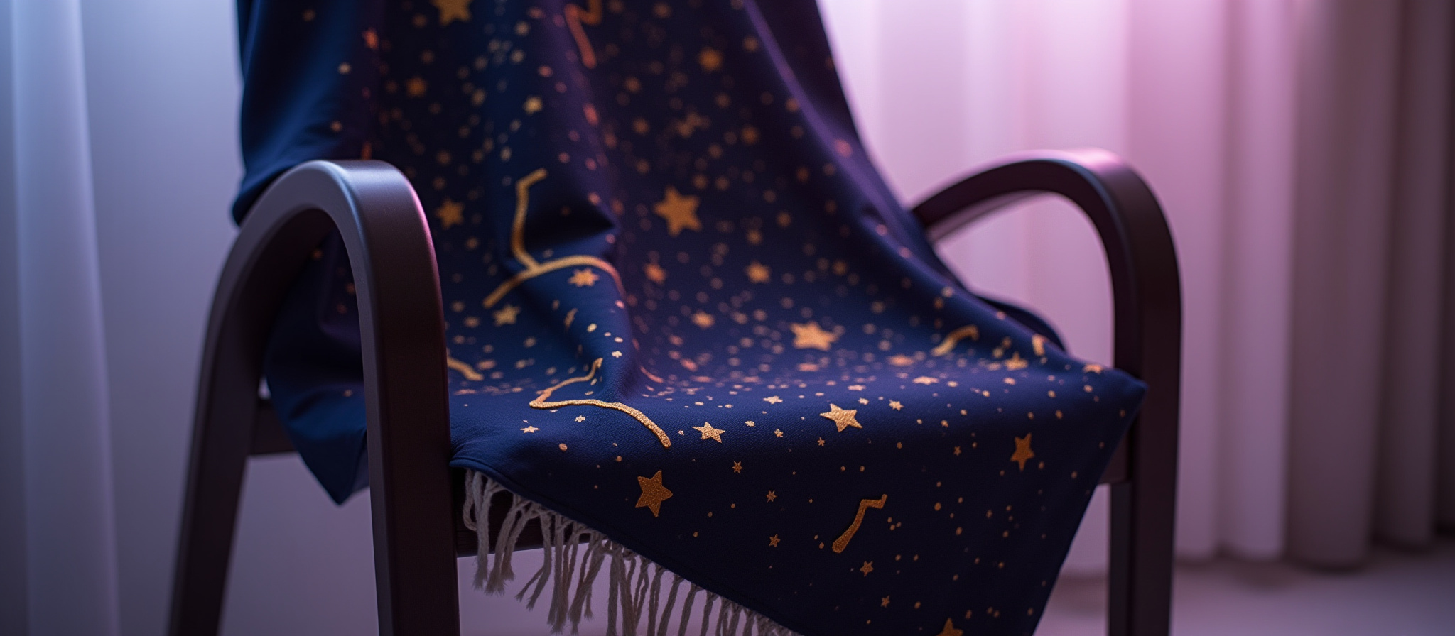 Dark blue blanket with gold stars draped over a wooden chair.
