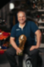 Steffen Drabe sitzt mit einem goldenen Pokal in der Hand