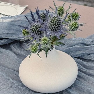 Elegante Tischdekoration mit Tischläufer, Kerzen und Blumengesteck für Business Event