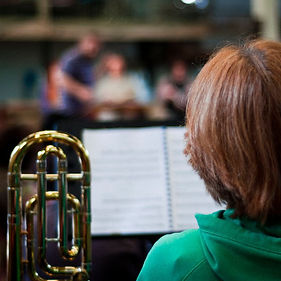 Alison Knight with trombone and music stand in rehearsal