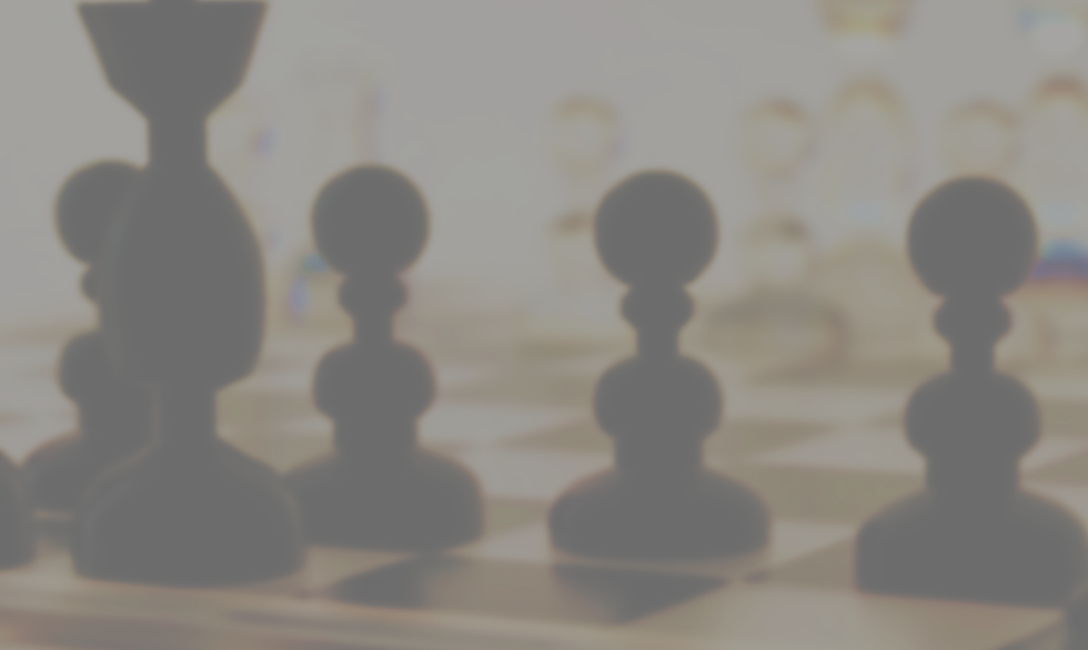 Blurred chess pieces on a board in soft beige tones, suggesting a quiet strategy game scene