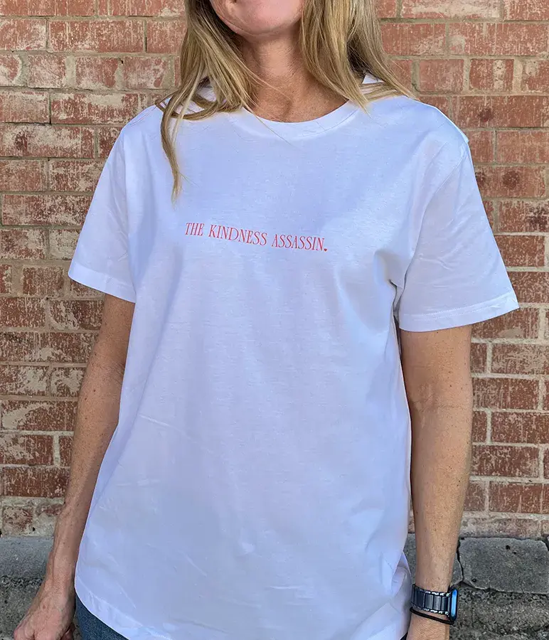 The Kindness Assassin women's graphic tee featuring statement typography on a classic round white neck t-shirt.