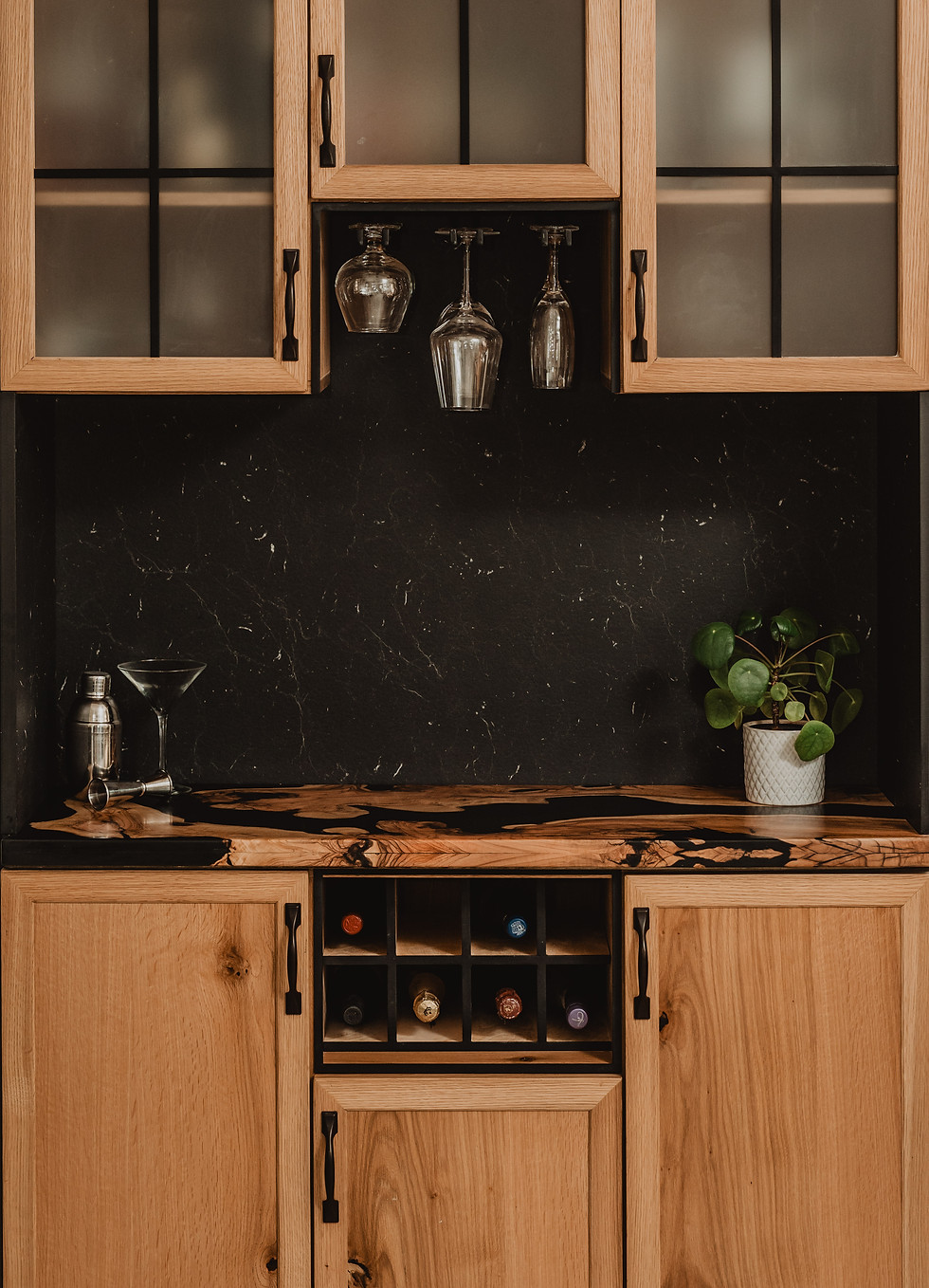Custom oak bar cabinet with black epoxy countertop and built-in wine rack
